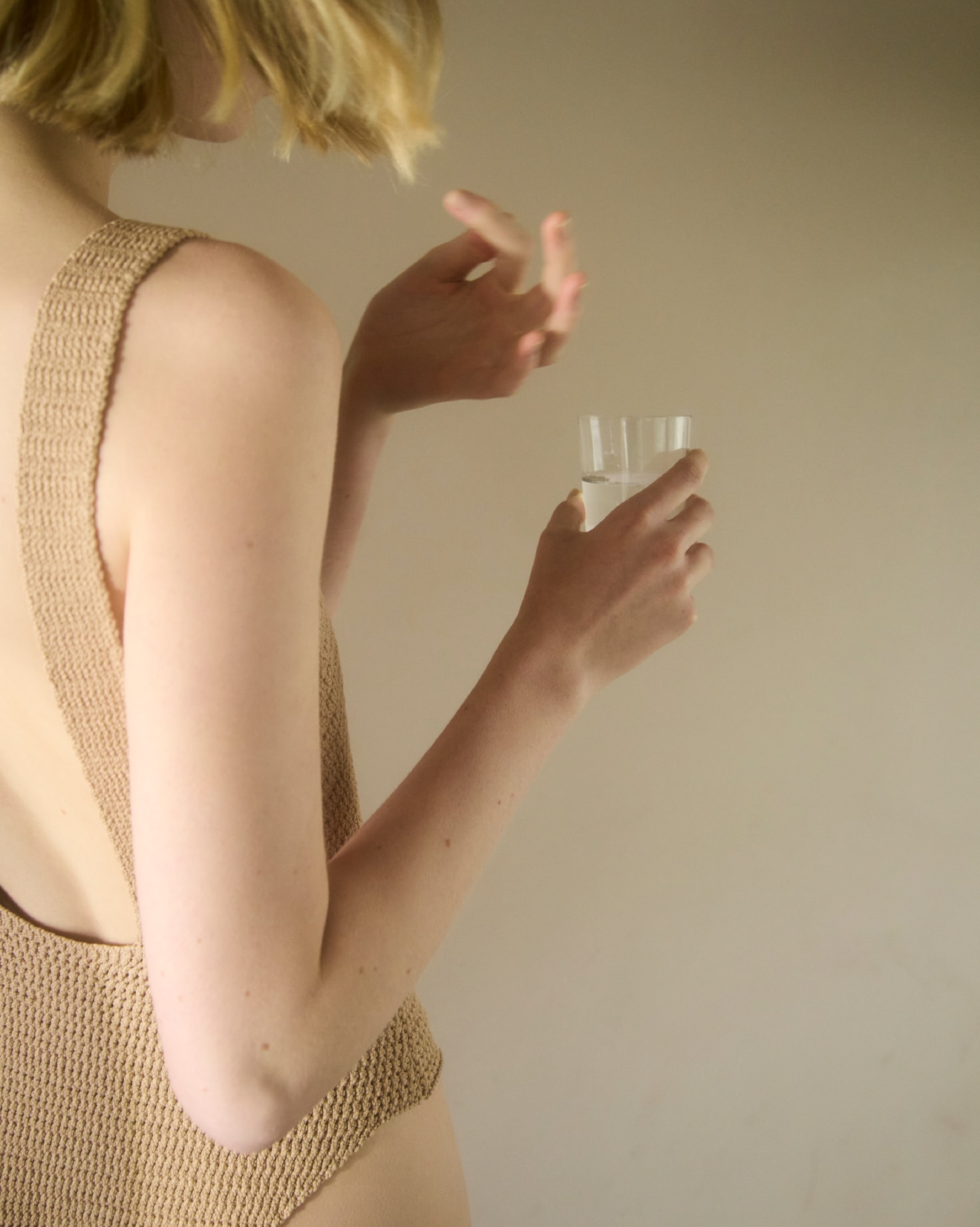 水の入ったコップを持つ女性のイメージ写真